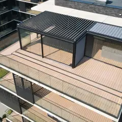 Nowoczesny dom z tarasem na dachu, przeszklonymi ścianami i pergolą. Widać jacuzzi pod przykryciem.