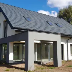 Nowoczesny projekt domu 50m2 z szarym dachem i dużymi przeszkleniami. Biało-szara elewacja, widoczne okna dachowe.