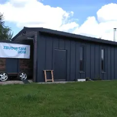 Mobilny projekt garażu 70m2 bez pozwolenia, z drewnianą częścią i metalową obudową, na kołach.