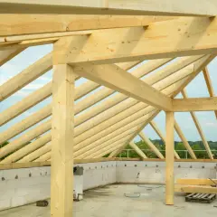 Solidne drewno na więźbę dachową, tworzące konstrukcję dachu nad budynkiem w stanie surowym.
