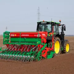 Traktor z siewnikiem Agro-Masz przygotowuje pole pod nasiona rzepaku na 1 ha.