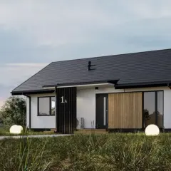 Nowoczesny dom modułowy co to? Elegancka bryła z drewnianymi akcentami, otoczona zielenią.