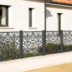 Nowoczesne, ciekawe ogrodzenia posesji z metalową ażurową siatką o geometrycznym wzorze liści.