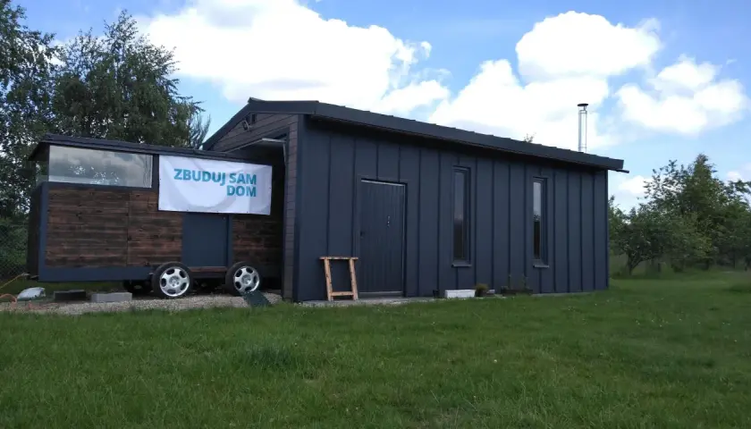 Mobilny projekt garażu 70m2 bez pozwolenia, z drewnianą częścią i metalową obudową, na kołach.
