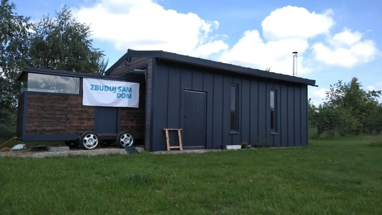Mobilny projekt garażu 70m2 bez pozwolenia, z drewnianą częścią i metalową obudową, na kołach.