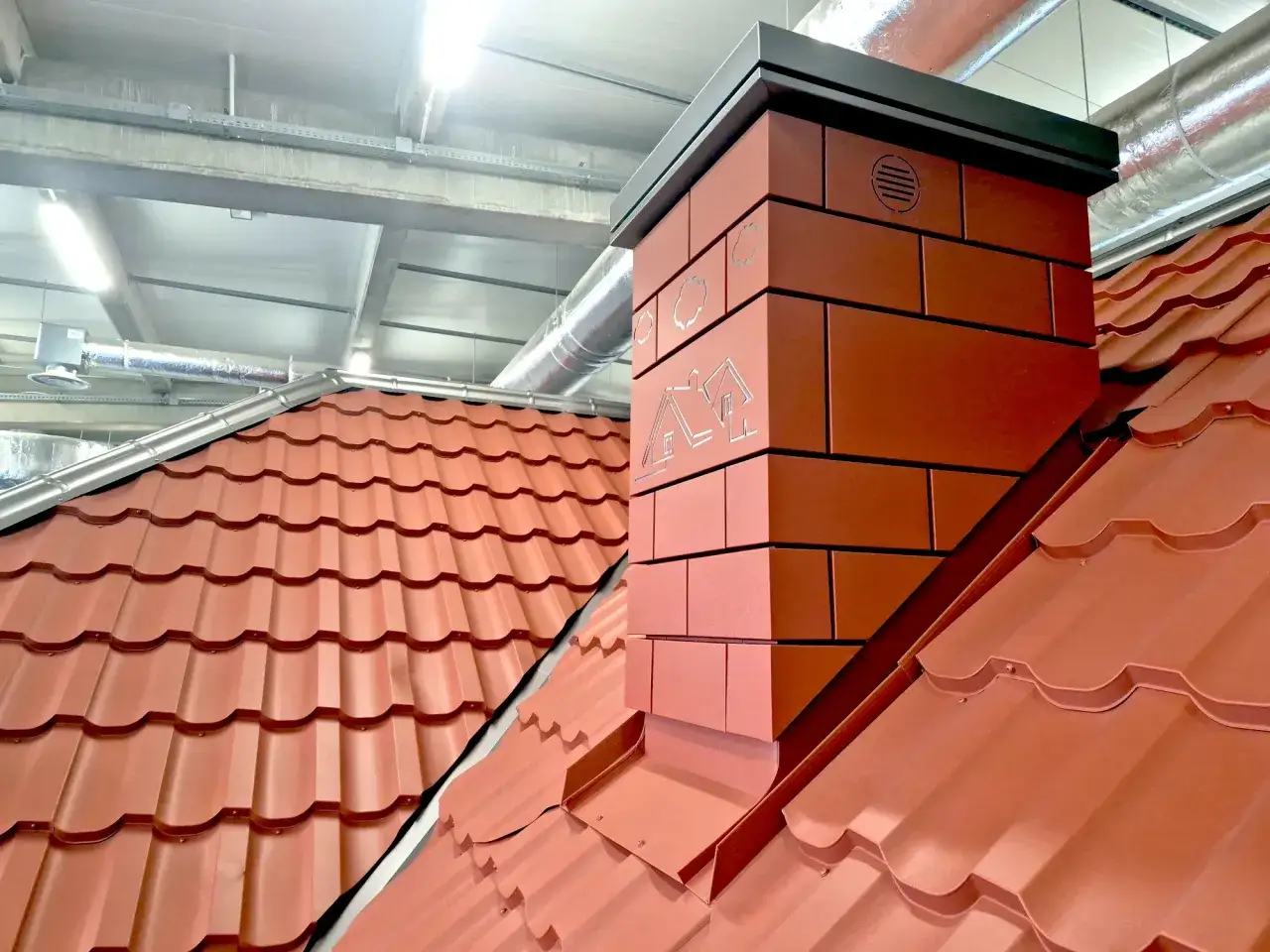 Nowoczesny komin na dachu z blachodachówki, pokazujący, jak uszczelnić komin od zewnątrz.