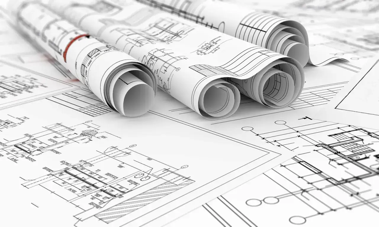 Zwoje dokumentacji technicznej, ukazujące szczegółowe plany architektoniczne. To projekt zamienny po zakończeniu budowy, gotowy do analizy.